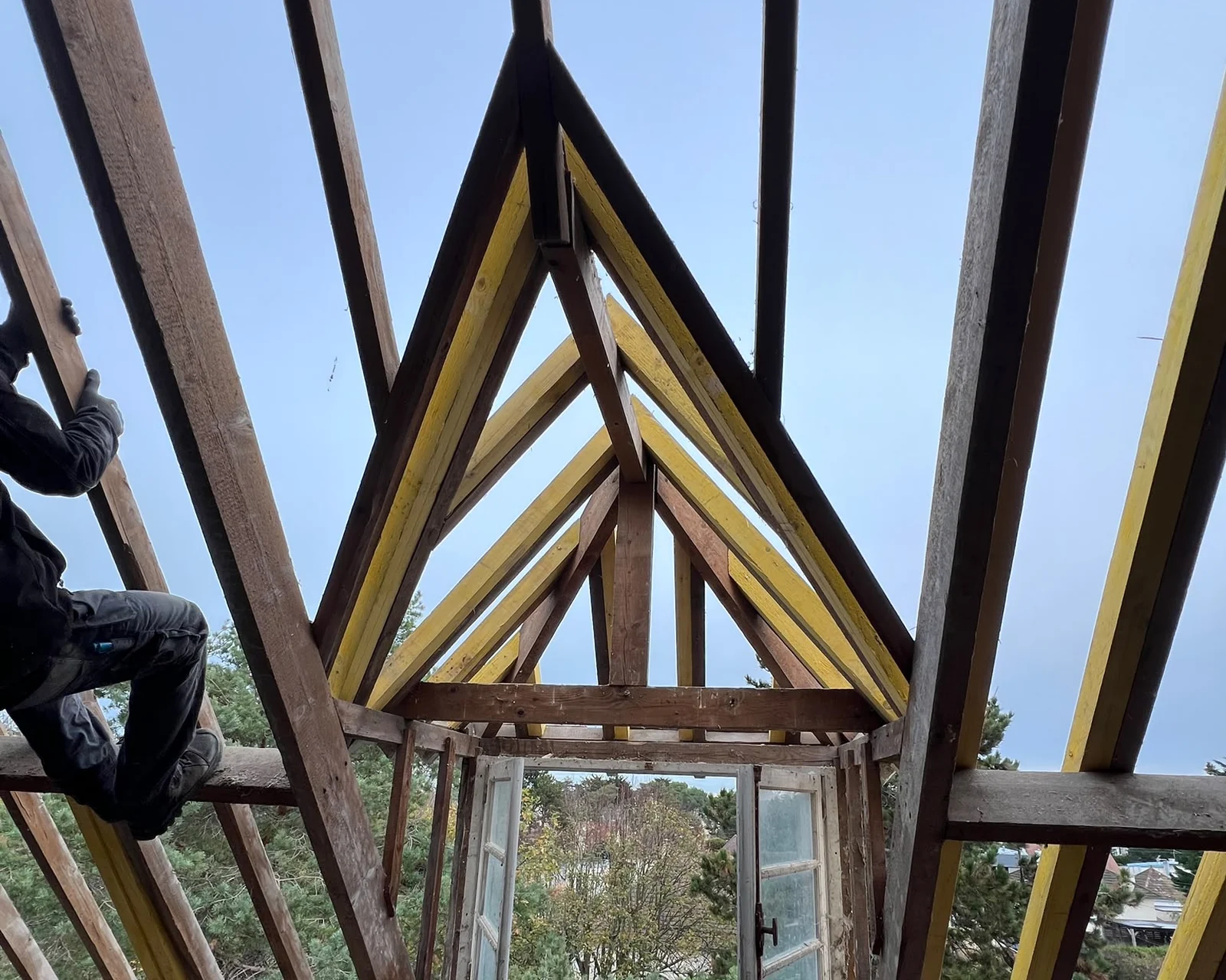 Charpente traditionnelle en bois avec ses fermes et ses pannes, vue depuis les combles