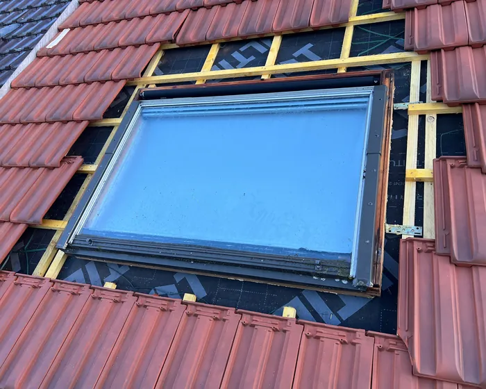 Fenêtre de toit Velux posée dans une couverture en tuiles avec abergement en zinc par Dim Toiture