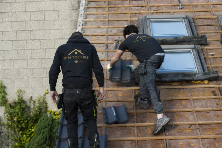 Deux couvreurs Dim Toiture posant des fenêtres de toit sur un liteaunage neuf à Cachan
